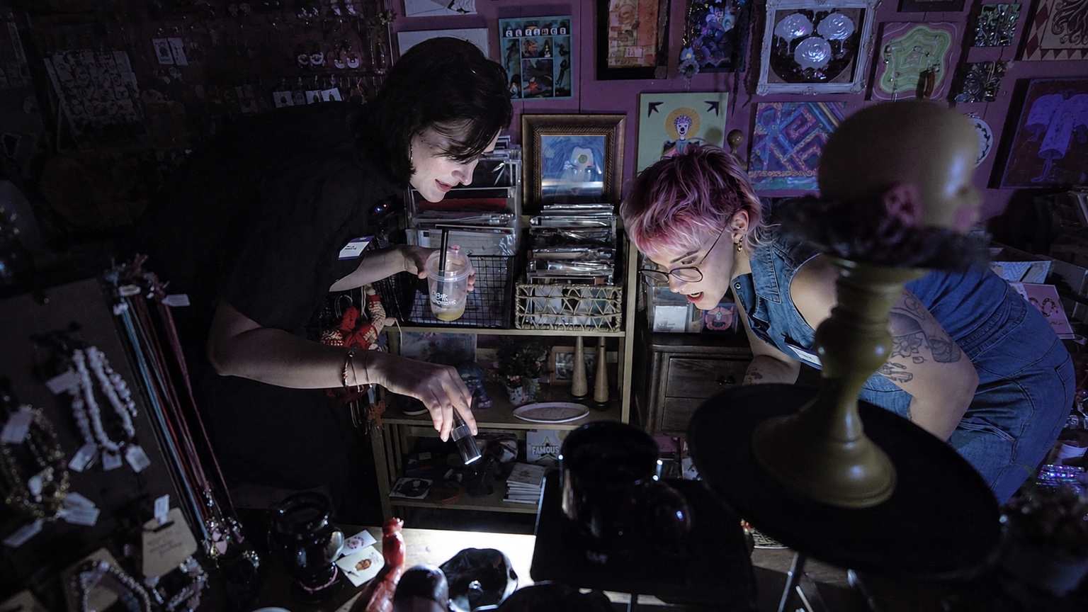 Two Buzz participants explore The Whimsy Artisan Boutique by flashlight